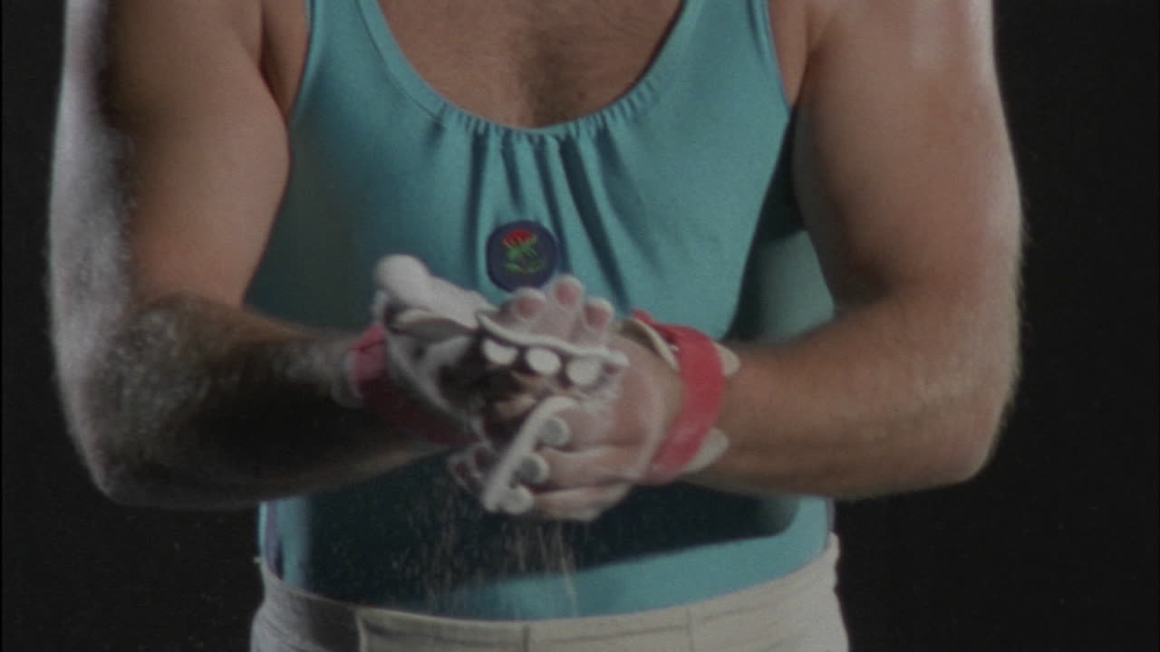 un gimnasta se empolva las manos