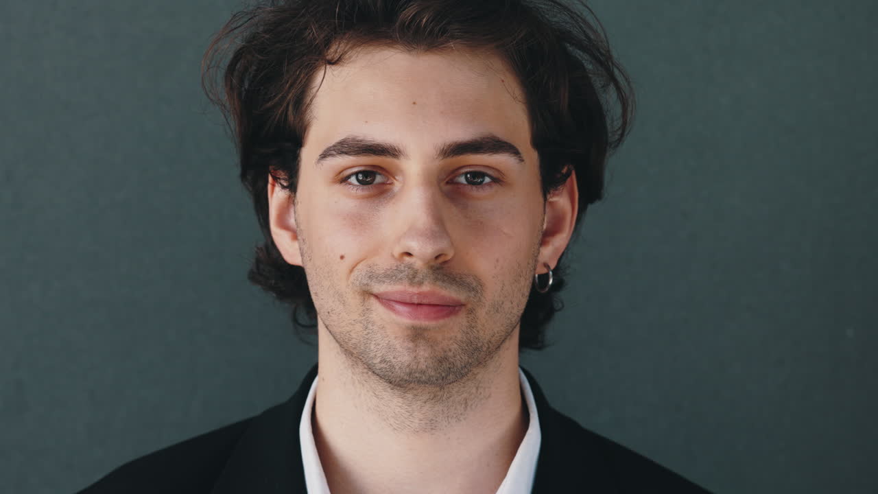 Close-up Portrait of a Young Man with Dark Hair and Stubble