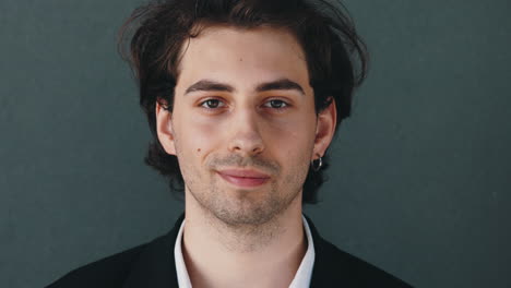 close-up portrait of a young man with dark hair and stubble
