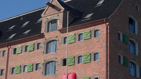 Traditional-brick-building-with-green-shutters-in-Copenhagen,-Denmark