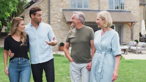 family with senior parents and adult offspring walking and talking in garden together