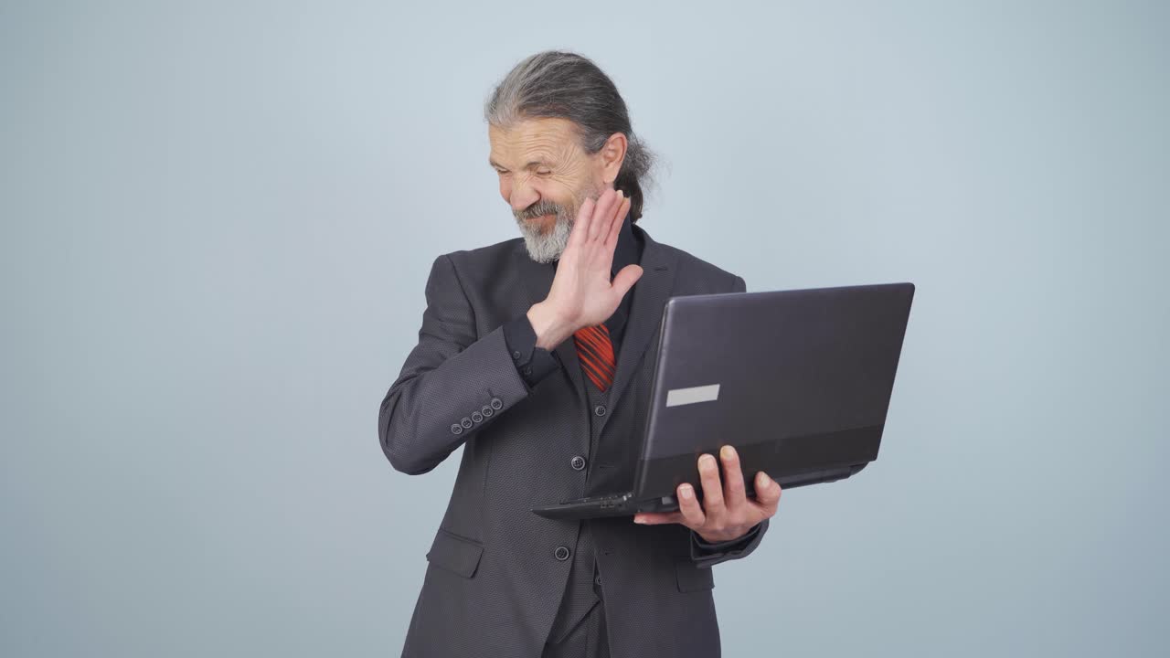 사업가는 겁에 질린 표정으로 노트북을 쳐다보고 있습니다.