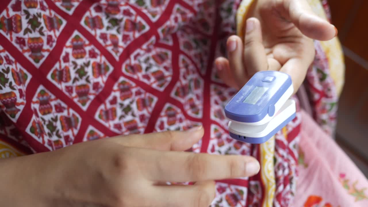 mujer usando un oxímetro de pulso