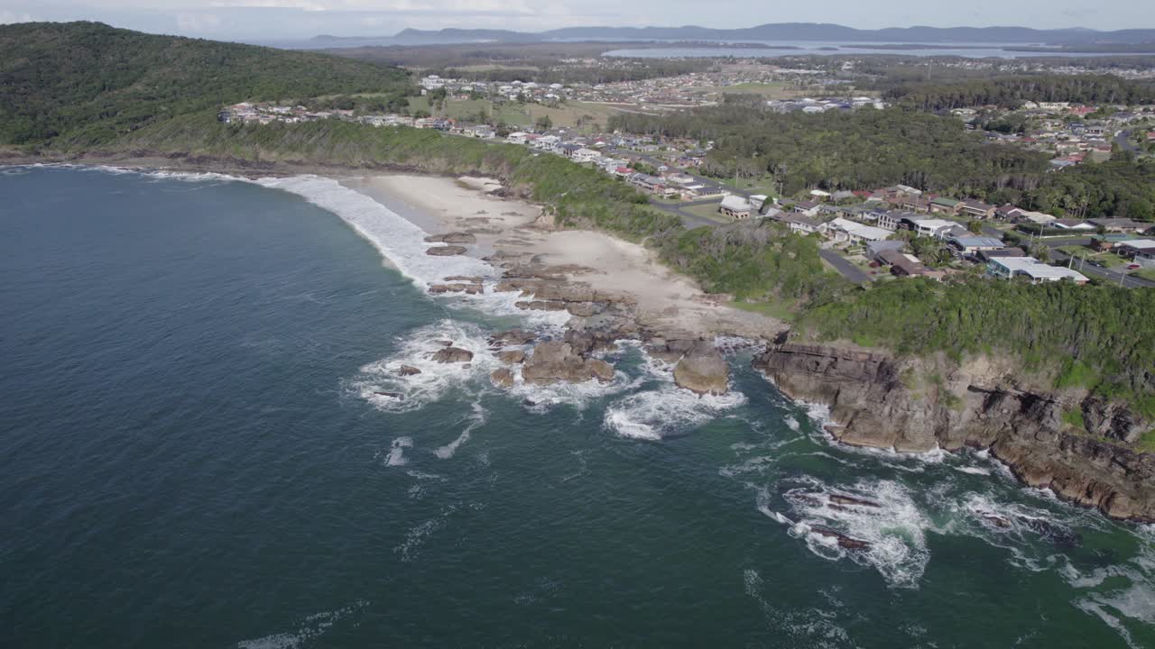 rocky burgess beach y ciudad costera de forster en un acantilado cubierto de vegetación en nueva gales del sur, australia