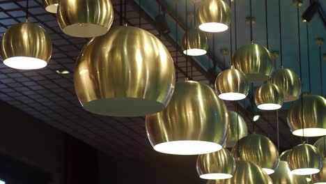 closeup of a modern gold chandelier hanging from a ceiling