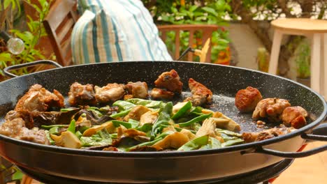 cocinando paella valenciana en una sartén grande - toma de cerca