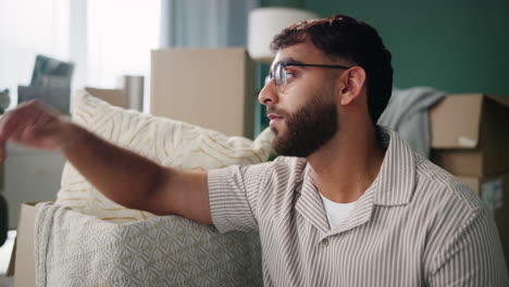 a man feeling stressed and tired surrounded by moving boxes