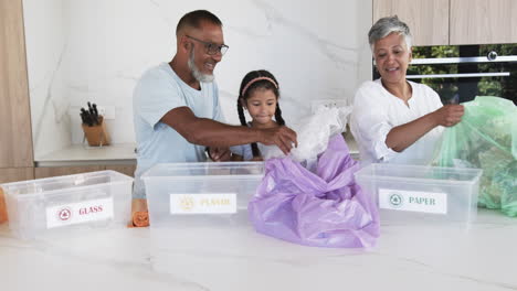 biracial family sorts recycling materials in a modern kitchen