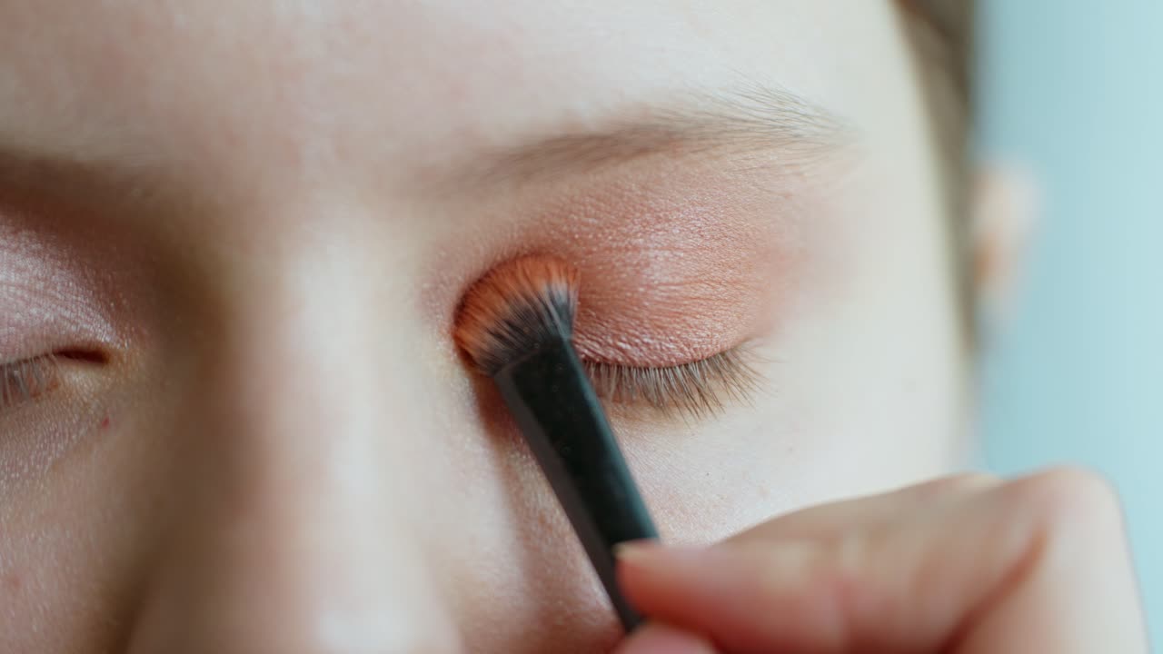 Applying Orange Eyeshadow
