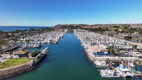 boats moored at dana point harbor with yacht club and restaurant in california, usa