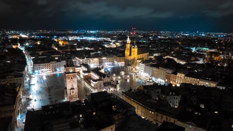 aerial hyper-lapse above the city center of the polish city of krakow at night with the landmarks buildings like st mary´s basilica, town hall tower and rynek główny in the market square, old town