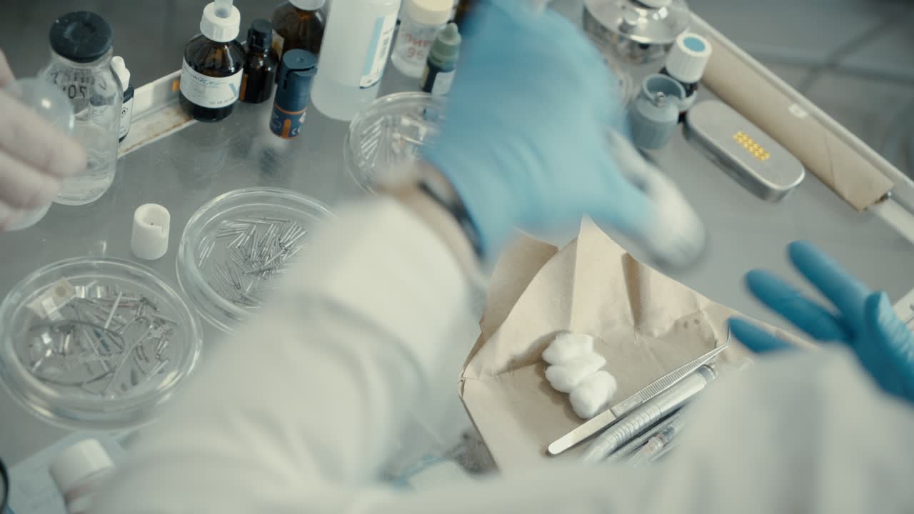 치과 의사는 테이블에서 장비를 가져옵니다.