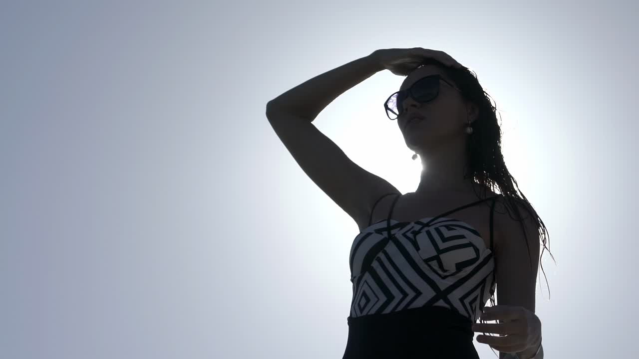 Beautiful girl with wet hair against the sun in slow motion