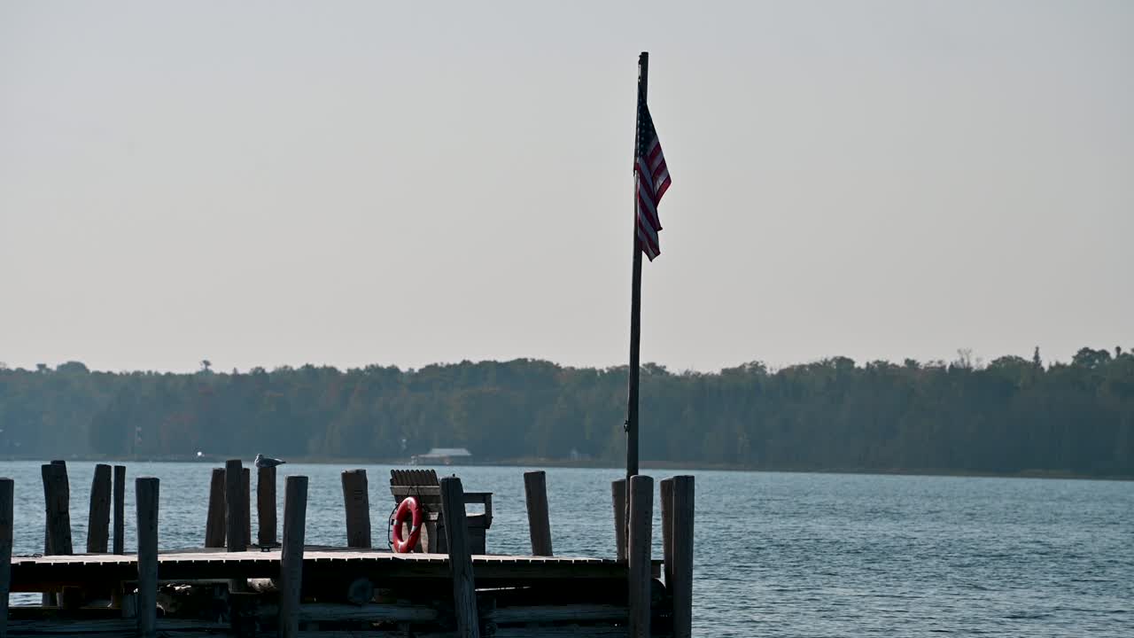 bandera estadounidense en el extremo del muelle en hessel, michigan, lago huron