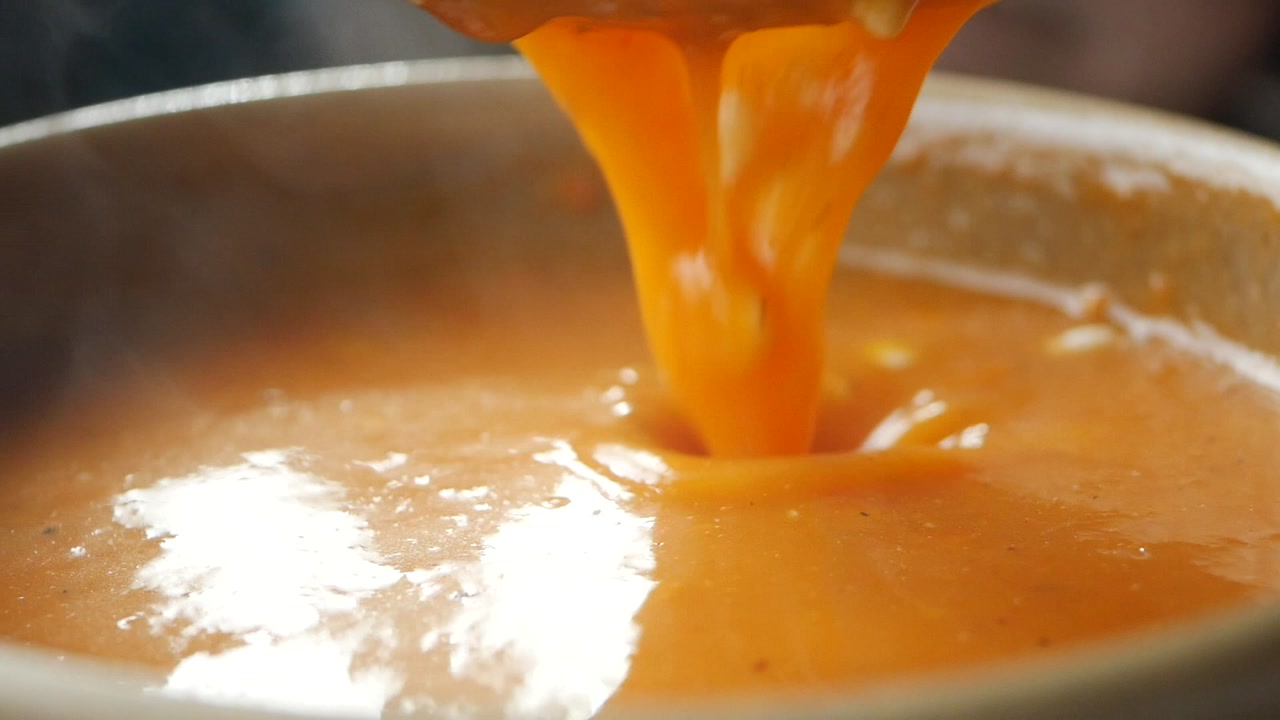Close-up of Hot Creamy Soup Being Stirred with a Spoon