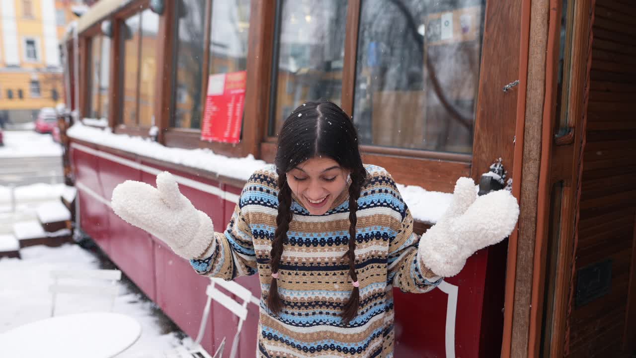 카페 근처 에서 눈이 내리는 것 을 즐기는 여자