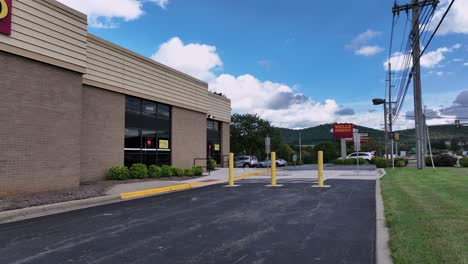 welle fargo bank building along american highway in virginia. aerial low angle flight. man walking from parking area to store. daytime in american suburb. river ridge mall in lynchburg.