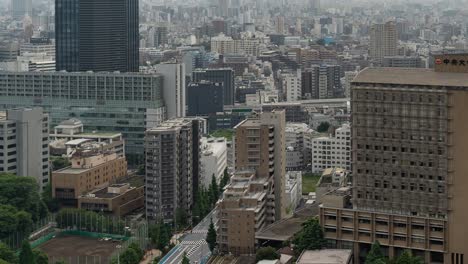 muy por encima de lapso de tiempo del horizonte de tokio con rascacielos en la distancia y el tráfico - tiro inclinado hacia arriba