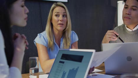video de diversas compañeras y compañeros de trabajo usando computadoras portátiles, trabajando hasta tarde en la oficina