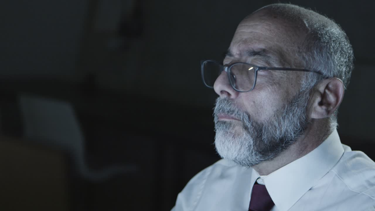 empresario fruncido de cejas con gafas en el lugar de trabajo