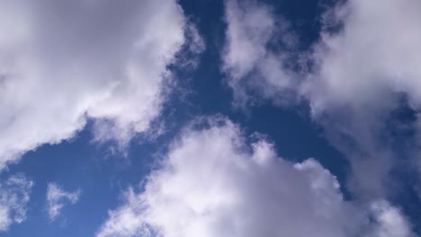 dramatic timelapse of dark and light clouds passing overhead with bluesky background