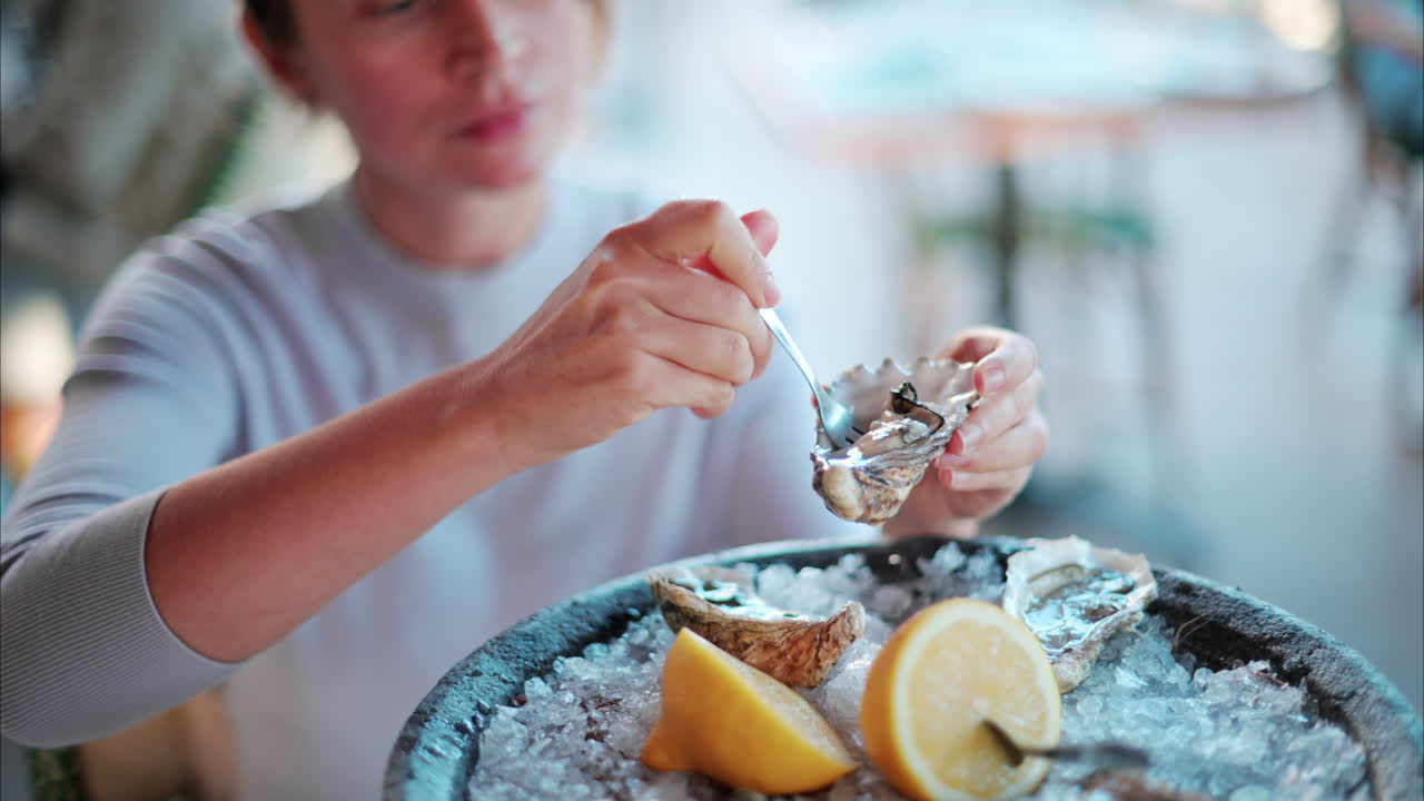 Woman eating raw oyster at a restaurant