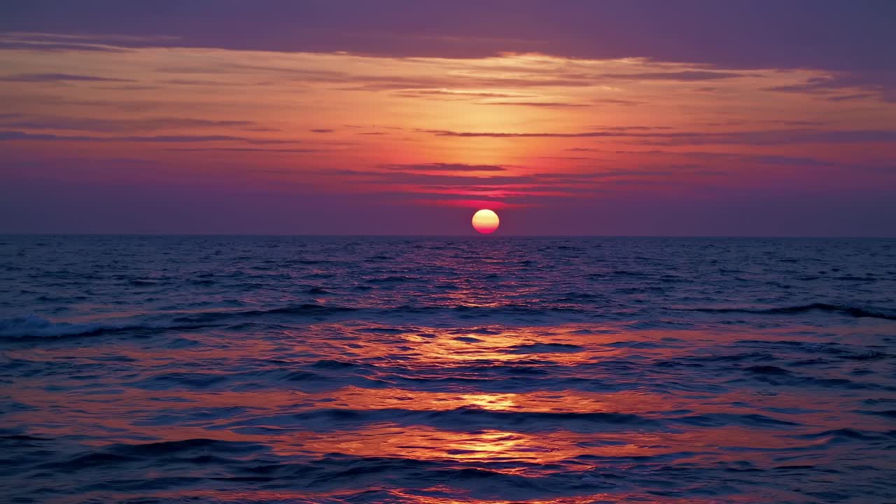 A stunning sunset over the ocean captured from a low-angle, perfect for a serene video backdrop