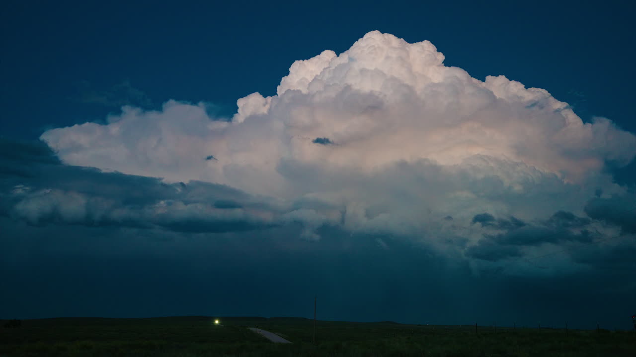Dramatic Cloud Formation Over Dark Landscape at Dusk