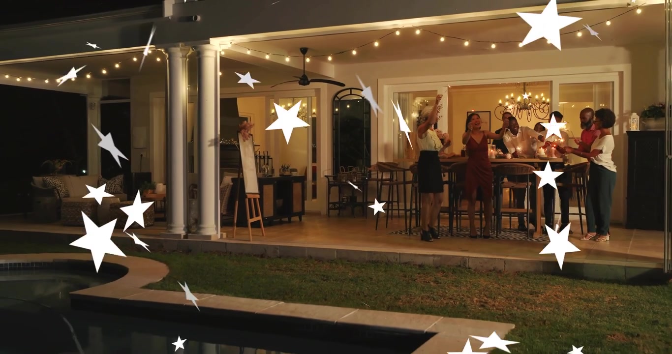 Matriarch handing sparklers emitting glowing trails wedding guests toasting patio string lights