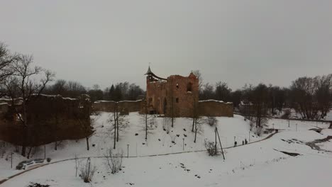 ruins of ancient livonian order's stone medieval castle latvia aerial drone top shot from above . restored castle capella at winter in dobele city. 4k resolution