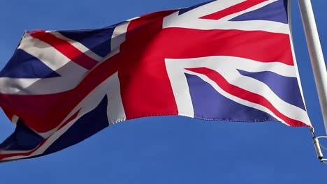 united kingdom flag moving by the wind on the blue sky