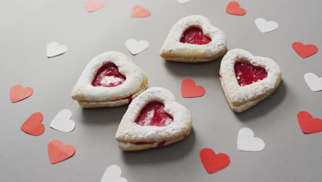 paper hearts and cakes on green background at valentine's day