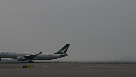 cathay pacific airplane landing on the runway at hkia airport