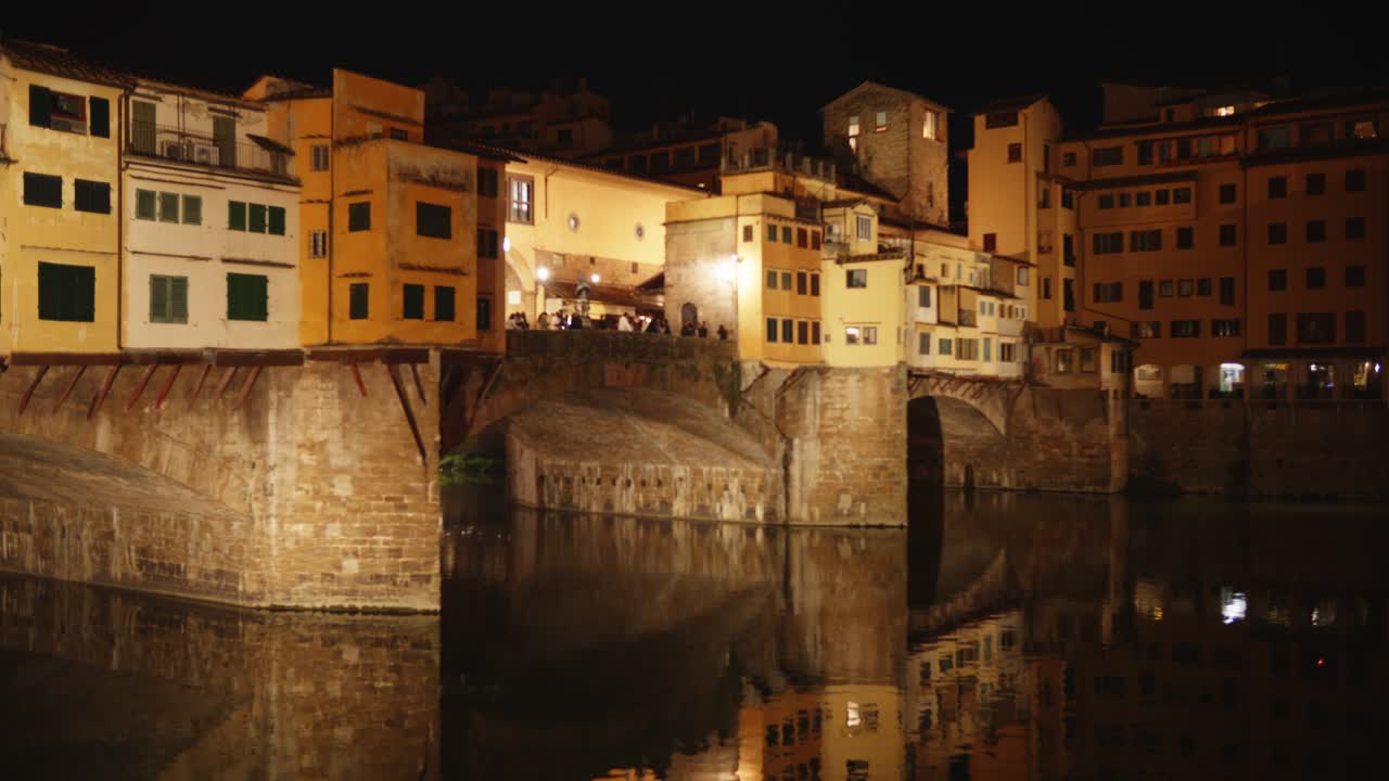 Ponte Vecchio a Firenze, Italia, di notte con i riflessi del fiume