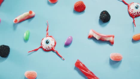 close up view of multiple halloween toys and candies against blue background