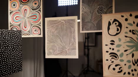 a close-up view of various hanging abstract artworks with diverse patterns and colors