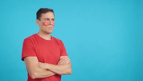Man with vietnamese flag painted looking away with serious expression