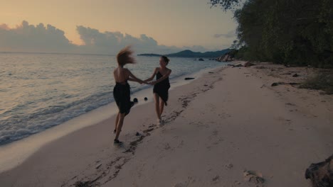 women dancing on the beach at sunset