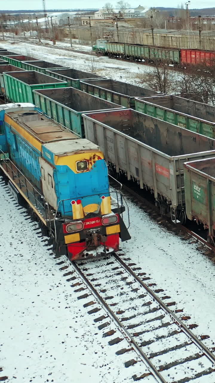 Cargo Trains And Containers At Terminal. Long railway freight trains with lots of wagons, aerial view. Vertical video