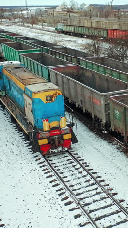 cargo trains and containers at terminal. long railway freight trains with lots of wagons, aerial view. vertical video