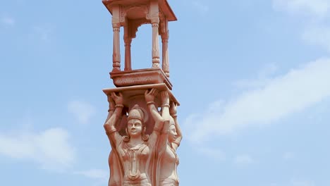 artistic-red-stone-jain-god-holy-pillar-at-morning-from-unique-angle-video-is-taken-at-Shri-Digamber-Jain-Gyanoday-Tirth-Kshetra,-Nareli,-Ajmer,-Rajasthan,-India