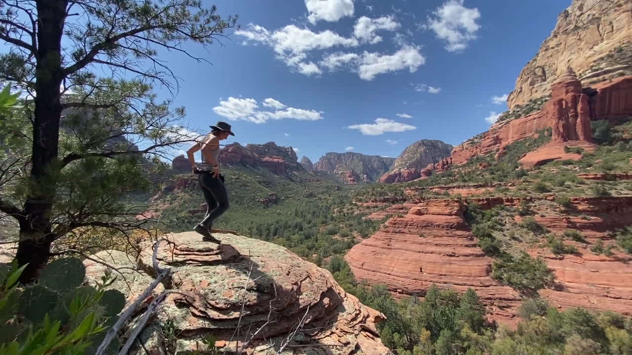 mujer joven en la cima de la roca sobre el impresionante paisaje de sedona, arizona, estados unidos en un día soleado