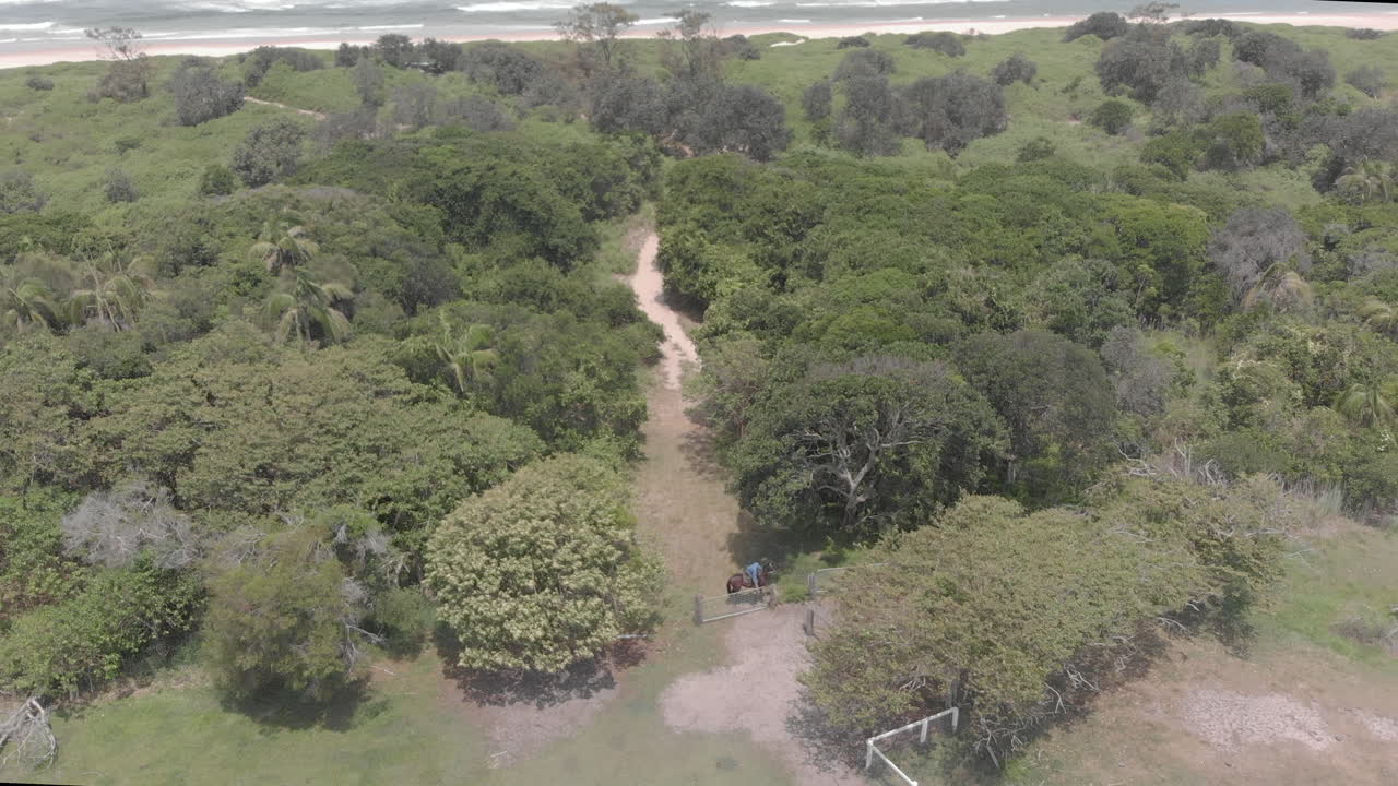 vista aérea del hombre a caballo cerrando la puerta de entrada al sendero del bosque