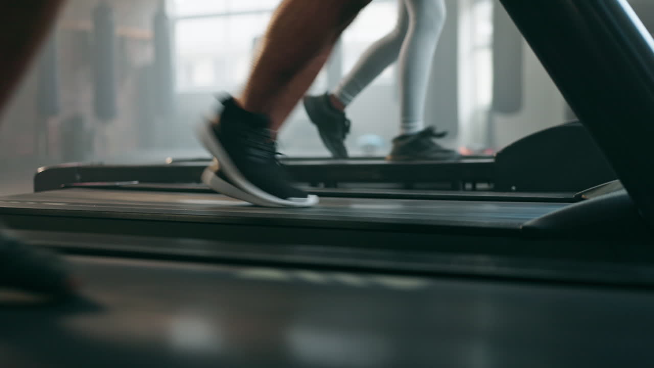 Feet, exercise and running shoes on a treadmill
