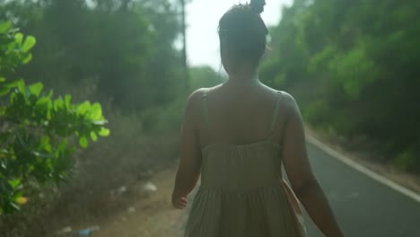 Woman-walking-down-a-road-in-the-evening