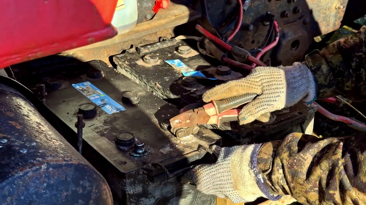 Technician repairing electronic device with exposed wiring and components on workbench