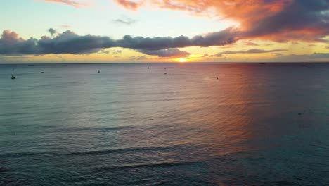 Puesta-De-Sol-De-Vacaciones-En-Hawaiin-Sobre-Las-Olas-Del-Océano-Y-Barcos-Que-Navegan-A-Los-Turistas-A-Través-Del-Mar-Colorido-Cerca-De-La-Playa-De-Waikiki-En-Honolulu,-Hawaii