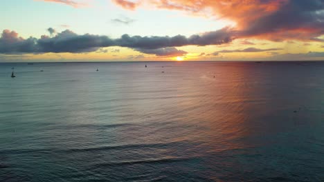 puesta de sol de vacaciones en hawaiin sobre las olas del océano y barcos que navegan a los turistas a través del mar colorido cerca de la playa de waikiki en honolulu, hawaii