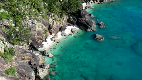 Revealing-drone-shot-of-beach-and-rocks-at-Hook-Island-near-Whitsunday-Australia