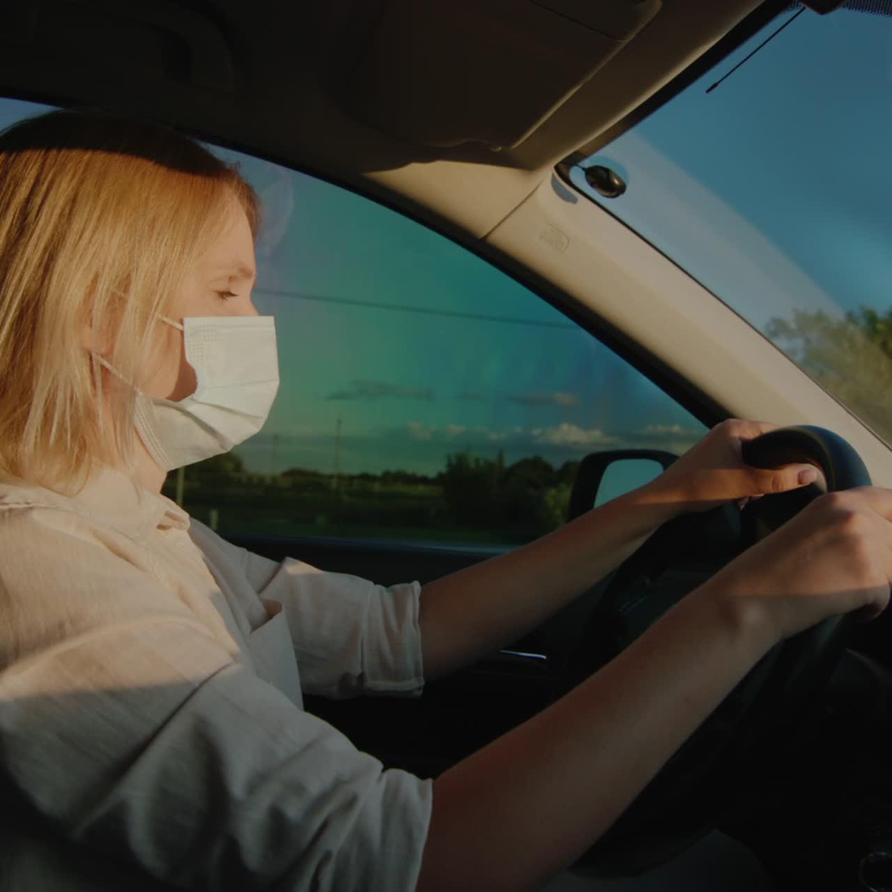 Autista con mascherina protettiva guida al volante di un'auto 1.